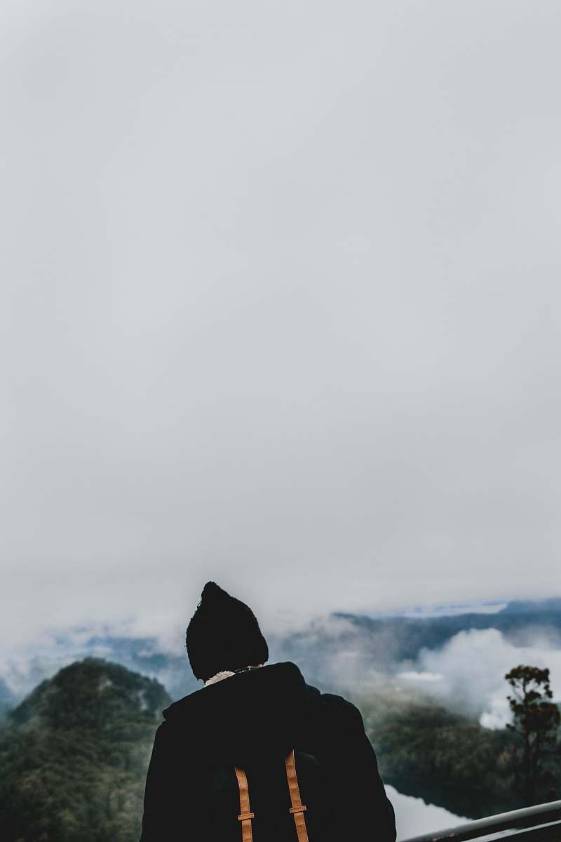 cerro campanario man wearing black jacket and knit cap facing green mountains san carlos de bariloche